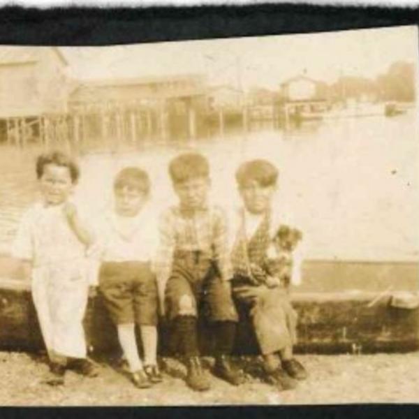 Boys sitting by marina, QFN Archives